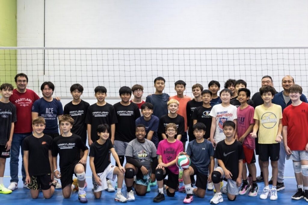 Mixed-age MVP Boys team photo with three coaches at AAU Nationals, showing players of all ages together